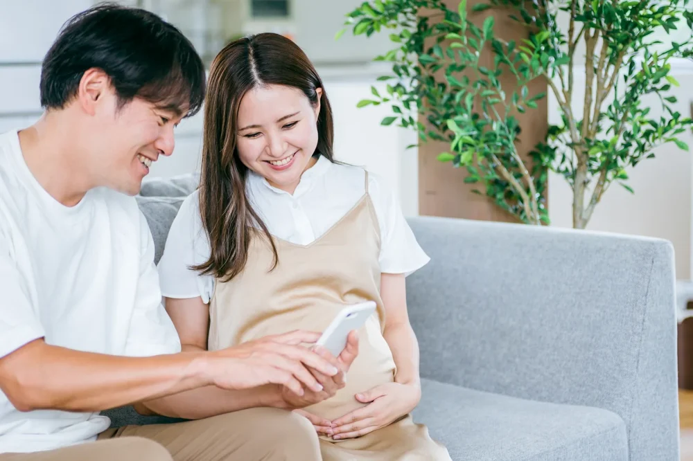 スマートフォンの画面を一緒に見る夫婦