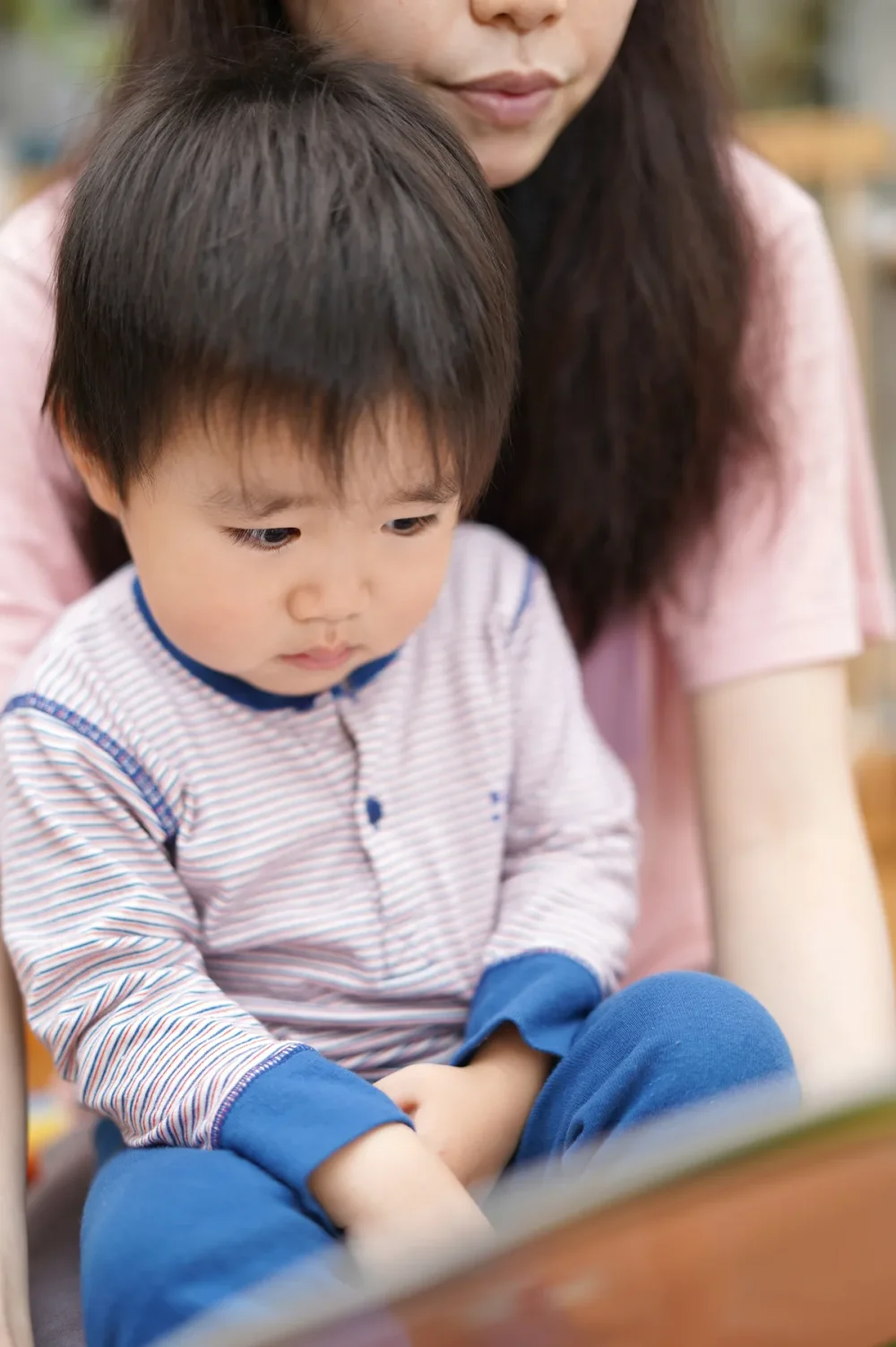 おうち時間中に絵本の読み聞かせをする親子