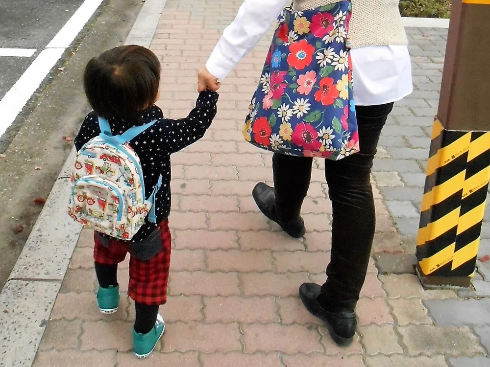 手を繋いで歩く大人と子ども