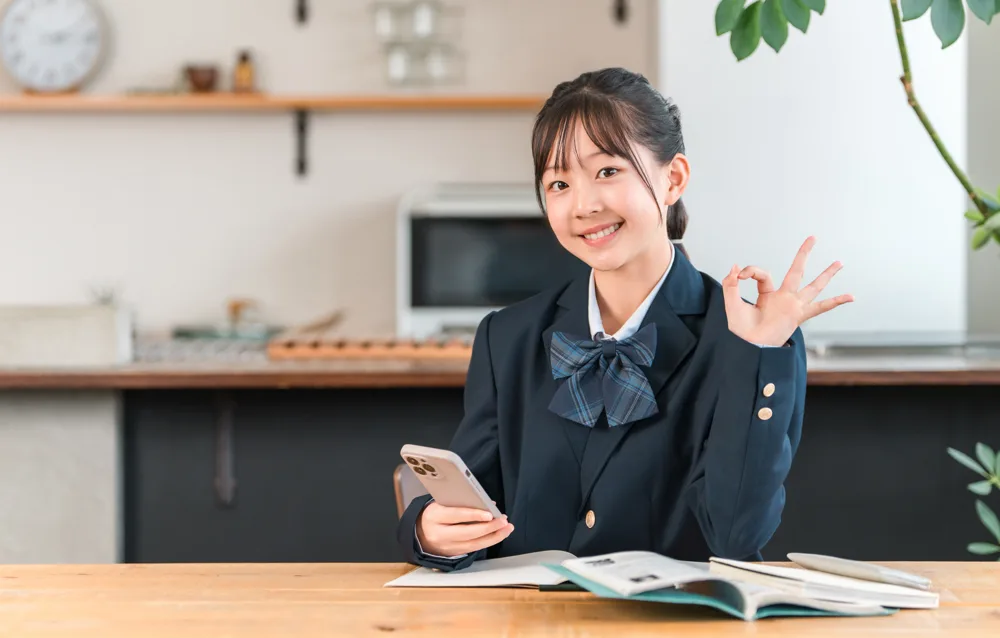 家でスマホを使って勉強する中学生