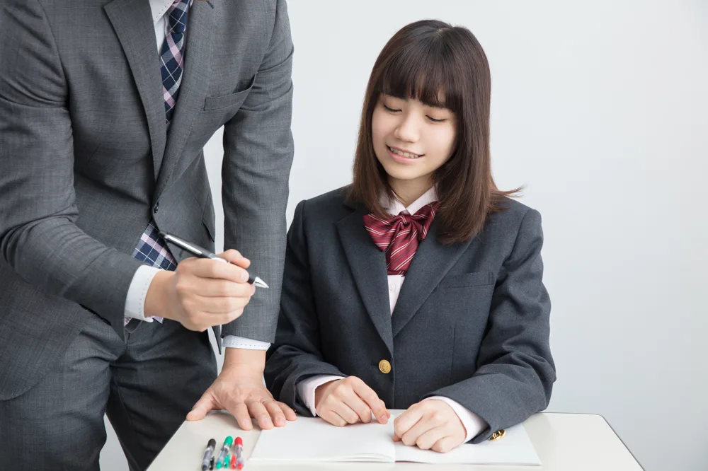 先生に教わりながら勉強する生徒